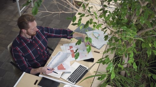 The Bearded Man Sits In The Environmental Office And Looks At The Figures On Paper.