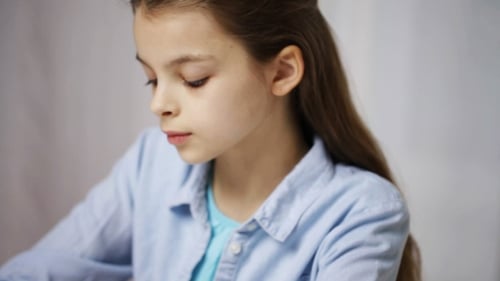 Bored School Girl With Books And Notepad At Home
