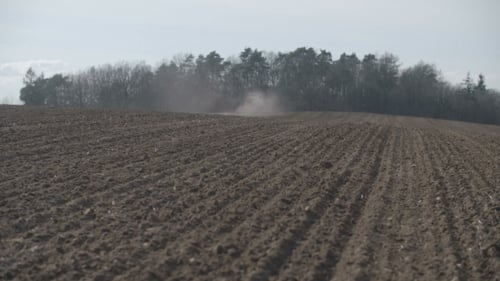 Tractor Plowing Field At Sunset