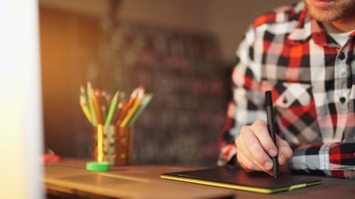 Man Drawing on Graphics Tablet at Desk