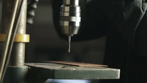 Arbeiter entfernen Metallspäne aus dem Bohrer