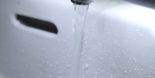 Running Faucet Water in a Shiny White Sink