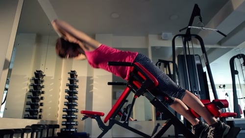 Young Woman Doing Exercise For Back At The Gym