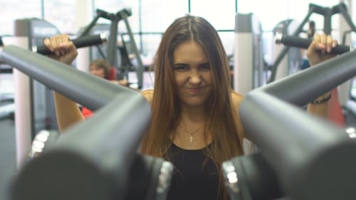 Woman Exercising Arm Muscles in Gym