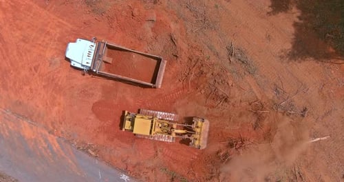 Aerial View on Excavators Work on Construction Site Dumping Earth for Loading Onto Dump Trucks