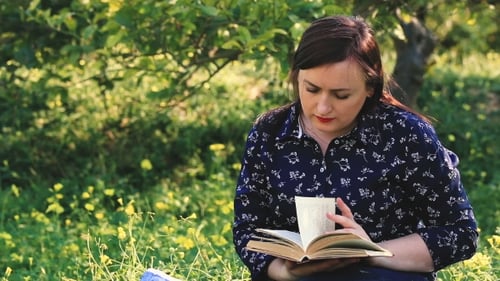 Attractive Woman Reading Book In Park.