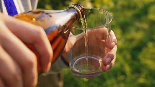 Beer Being Poured into Glass Outside