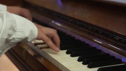 Person Plays the Piano in White Shirt