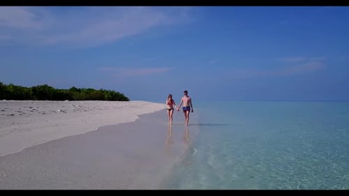 Young couple happy together on luxury lagoon beach journey by transparent sea with white sandy backg