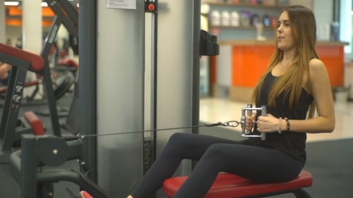 Woman Doing Seated Rows on Cable Machine in Gym