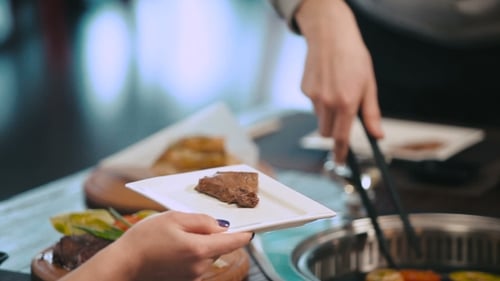 Male Hand Put On Plate Grilled Meat And Vegetables