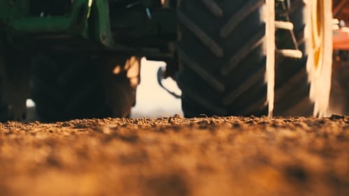 Tractor Plowing Field At Sunset