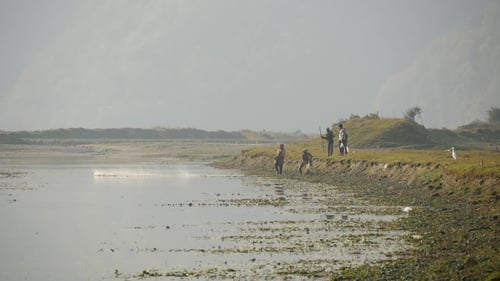 People Fishing by Lake in Rural Setting
