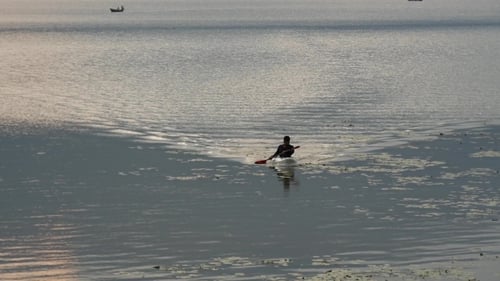 Woman Paddling Kayak on Calm Water
