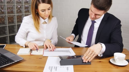 Man and Woman Reviewing Business Documents Together