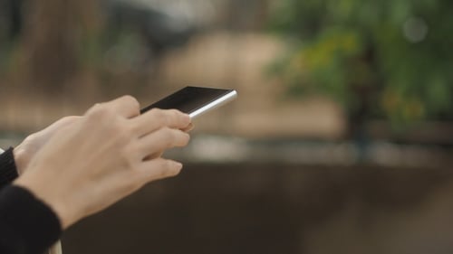 Hands Using Smartphone in Urban Setting