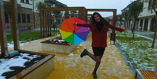 Smiling Woman Walking With Umbrella on Winter Day
