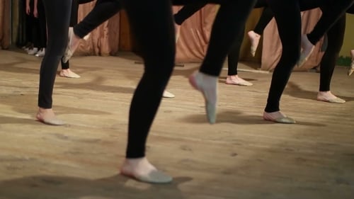 Young Women Practicing Ballet Footwork on Stage