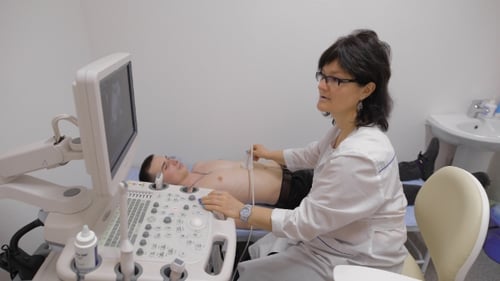 Doctor Performing Ultrasound on Young Adult Patient
