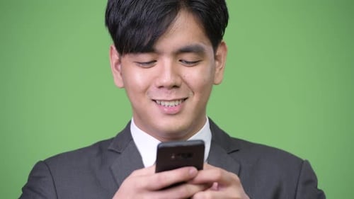 Man in Suit Uses Smartphone Smiling