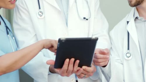 Doctors Reviewing Tablet in Medical Setting