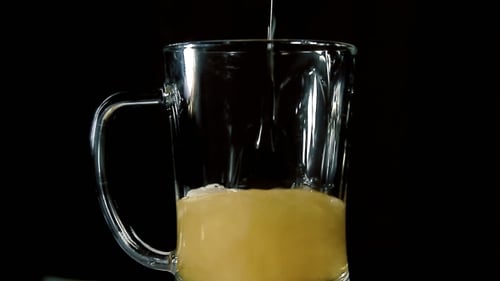 Beer Pouring into a Glass Mug Close Up