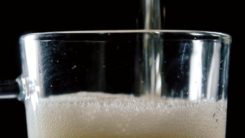 Foamy Beer Poured in Clear Mug Close Up