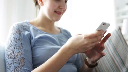 Woman Using Mobile Phone Indoors