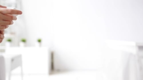 Woman's hands scrolling on white smartphone