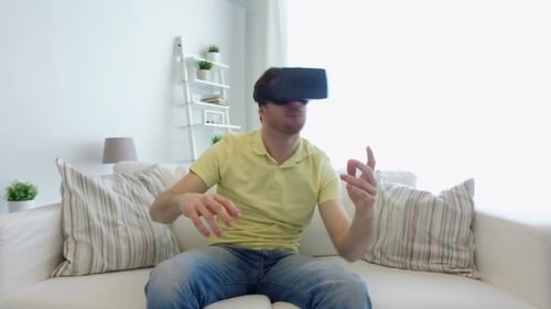 Man Experiencing Virtual Reality on Sofa at Home