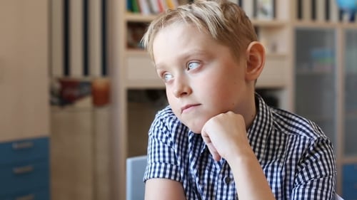 Blond Boy Ponders Thoughtfully Indoors