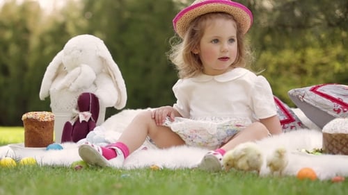 Glückliches Kind sitzt auf einer Wiese um die Osterdekoration