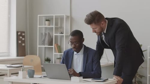 Two Diverse Traders in Suits Working Together in Office