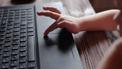 Child Uses Laptop Touchpad at Home