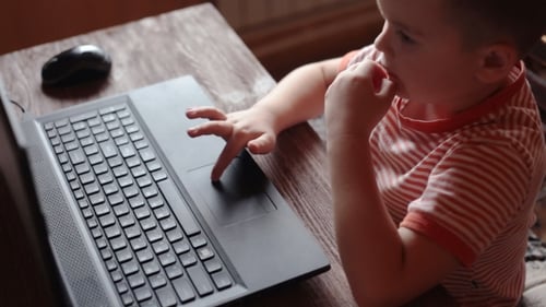Child Using Laptop Computer at Home on Table