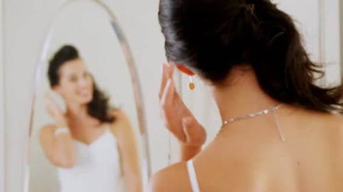 Bride Adjusts Earring While Looking in Mirror
