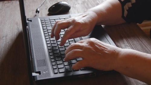 Hands Typing on Laptop Keyboard at Workplace