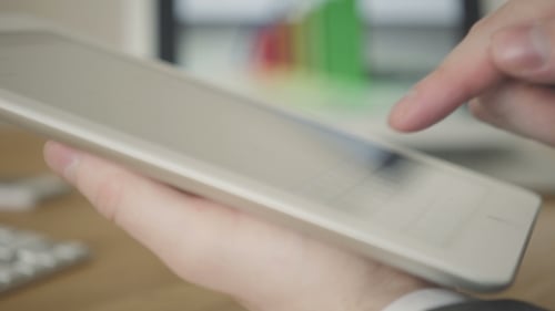 Adult Using Silver Tablet in the Office