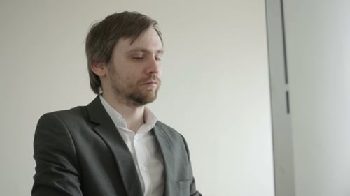 Erfahrener Geschäftsmann, der Finanzdaten mit Grafiken und Diagrammen betrachtet, während er am Laptop arbeitet