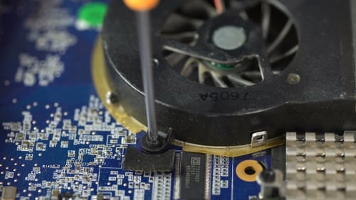 Screwdriver Removing Screw from Computer Motherboard