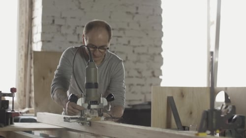 Craftsman Shaping Wood Plank in Bright Workshop