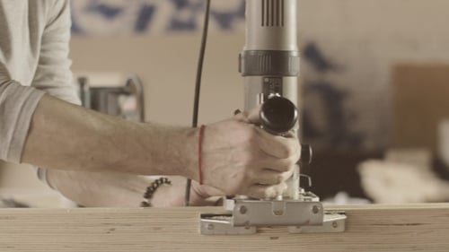 Man Smoothing Wood Edge With Power Tool