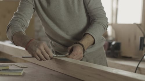 Adult Man Measuring Wood with Calipers