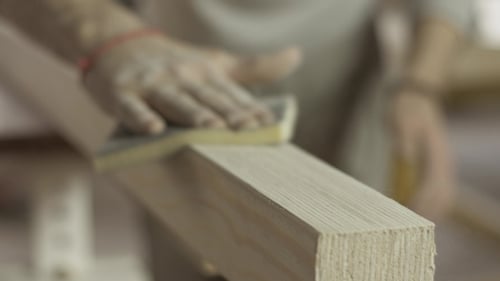 Man Sanding Wood In Carpentry Workshop
