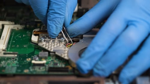 Computer Technician Repairs Electronic Device with Tools