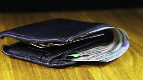 Wallet Full of Money on a Wooden Table