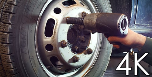 Mechanic Changing Truck Tire With Power Tool