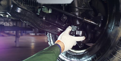 Mechanic Cleaning Car Undercarriage and Tire in Garage