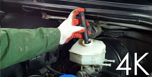 Mechanic Testing Brake Fluid In Car Engine