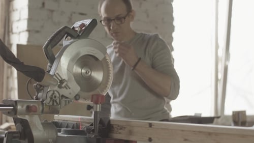 Adult Man Cutting Wood Using Chop Saw